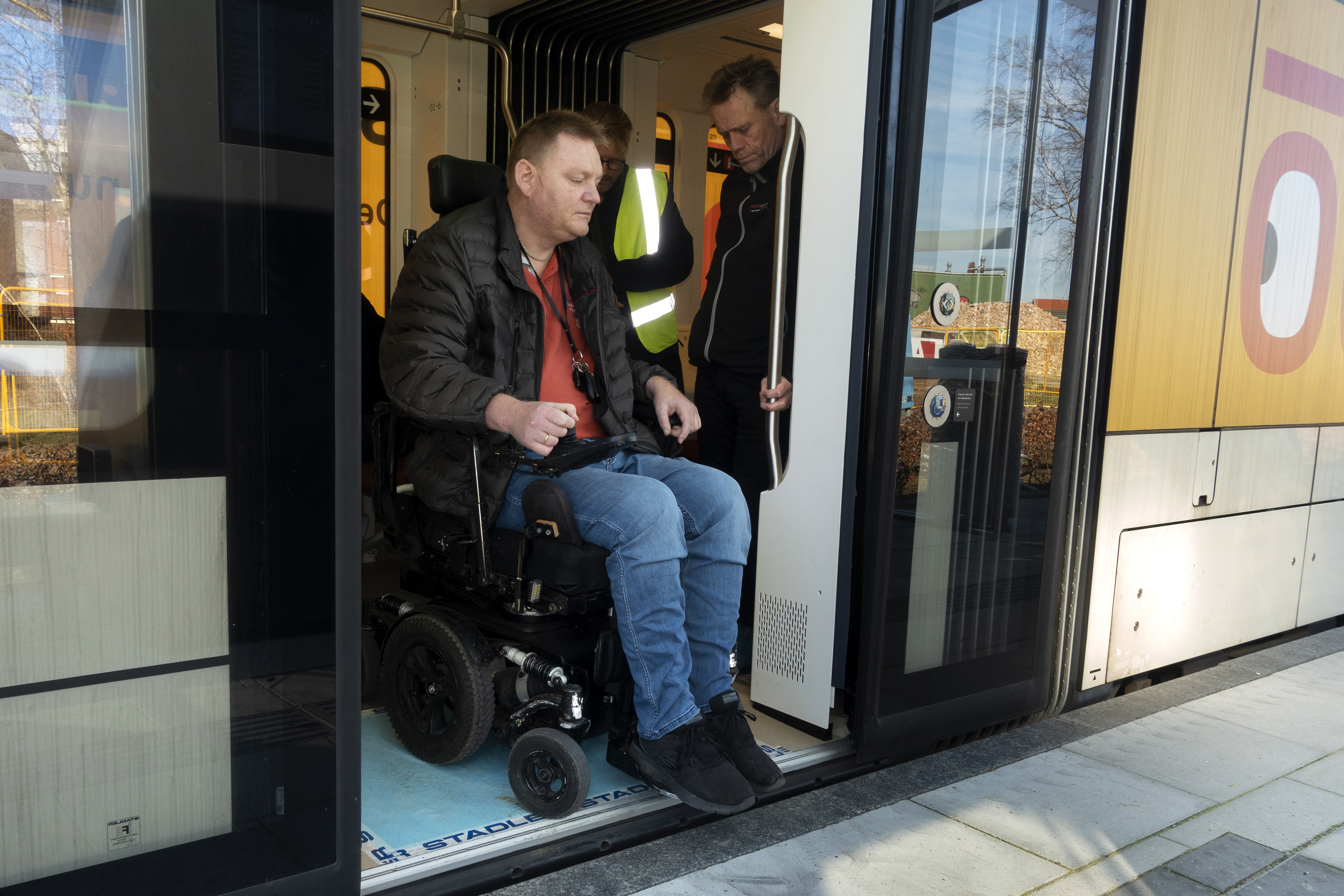 Kørestolsbruger på vej ud af letbanetoget